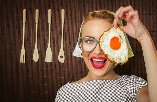 woman-smiling-holding-a-fried-egg